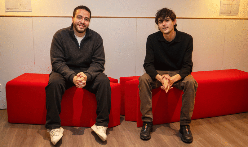 Los dos estudiantes de Product Design del IED Barcelona que han diseñado el banco sentados encima de él. 